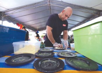 MOHAMED Ahmed Mahmoud Shokr menyediakan makanan jualannya di Bazar Ramadan di Johor Bahru.