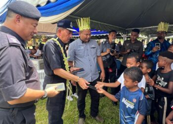 MUHAMAD Zaki Harun (dua dari kiri) menyampaikan duit raya kepada kanak-kanak Orang Asli di Kampung Pasir Linggi di Gua Musang, Kelantan, baru-baru ini. – UTUSAN/AIMUNI TUAN LAH