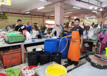 MUHAMMAD Hisyamuddin Jusoh menunjukkan bekas air yang digunakan untuk menyimpan air jika berlaku situasi kecemasan di kawasan pasar Siti Khadijah di Kota Bharu. - UTUSAN/ROSALWANI CHE SOH