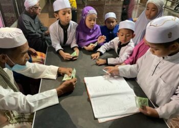 SEBAHAGIAN kanak-kanak menerima sagu hati RM5 selepas solat Subuh di Masjid Mukim Kampung Wakaf di Pasir Puteh, Kelantan. - UTUSAN/TOREK SULONG