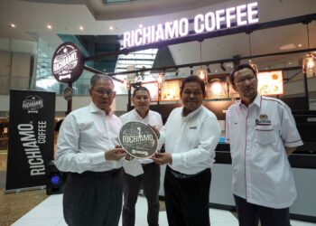 Mustapa Mohamed bersama Muhammad Zamry Abu Samah (dua kanan) bergambar di hadapan kiosk Richiamo Coffee pada pelancaran cawangan Richiamo Coffee ke-99 di Menara Prisma, Putrajaya, semalam.  
– UTUSAN/FAISOL MUSTAFA