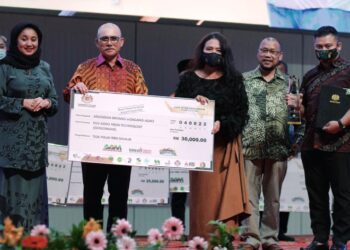 LYNN Alias (tiga, kanan) menerima cek berjumlah RM30,000 daripada Ronald Kiandee dalam satu majlis di MAEPS, Serdang, baru-baru ini.