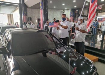 DR. Ahmad Samsuri Mokhtar memasang Jalur Gemilang di sebuah kereta rasmi kerajaan negeri pada Majlis Pelancaran Bulan Kebangsaan dan Kempen Kibar Jalur Gemilang Peringkat Negeri Terengganu di Kuala Terengganu, hari ini. - UTUSAN/ZAID MOHD. NOOR