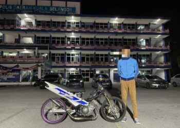SUSPEK bersama motosikalnya ditahan di hadapan IPD Kuala Selangor, semalam selepas rakaman videonya menguji motosikal yang diubah suai tular dalam media sosial.