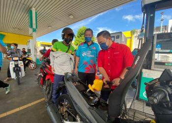 WAN Saiful Wan Jan (kanan) bersama Dzowahir Abdul Ghani pada Program Isi Minyak Percuma  di sebuah stesen minyak di Alor Setar hari ini. - UTUSAN/NUR ANATI JUHARI