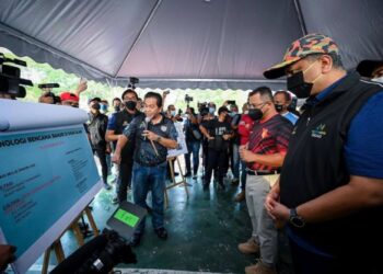 REEZAL Merican mendengar taklimat sebelum turut serta dalam program Mega Pembersihan Pasca Banjir di Sri Muda, Shah Alam, Selangor. -IHSAN KPKT