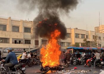 PENUNJUK perasaan berkumpul berhampiran sebelah motosikal yang terbakar di ibu negara Teheran.-AFP