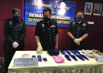 MOHD. Azmir Damiri (tengah) menunjukkan barangan dirampas berkait dengan dua kes dadah di IPD Tumpat hari ini.-UTUSAN/ROSLIZA MOHAMED