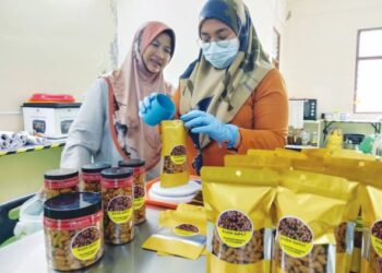 NORMA Md. Hashim (kiri) bersama pekerjanya di kilangnya di Bakau Tua, Butterworth, Pulau Pinang, baru-baru ini.
