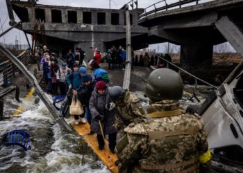 PENDUDUK menyeberang sebuah jambatan yang musnah akibat serangan ketika meninggalkan bandar Irpin, barat laut Kyiv di Ukraine. - AFP