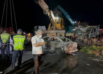 ANGGOTA polis dan pasukan penyelamat bekerja di sebelah kenderaan terbakar di lebuh raya Iskenderun-Antakya, selatan Turkiye. - AP