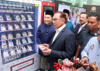 ANWAR Ibrahim diiringi Rafizi Ramli melihat mesin layan diri Inisiatif Pendapatan Rakyat (IPR) pada Majlis Rumah Terbuka Kementerian Ekonomi di Menara Prisma, Putrajaya, semalam. – UTUSAN/FAISOL MUSTAFA