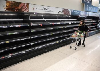 SEORANG penduduk berjalan melepasi rak makanan yang kosong di Manchester, utara England. - AFP 