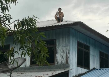 KANTAPHI duduk atas bumbung rumah selama dua hari kerana tidak dibenarkan menghisap ganja. - AGENSI