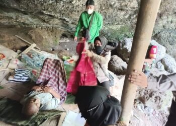 ANGGOTA polis mengemas barangan sambil disaksikan Yudi (terbaring) ketika dia dibawa keluar dari sebuah gua di Lawang, Malang, Jawa Timur. - AGENSI