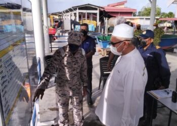 RAZMAN Zakaria (kanan) diberi penerangan mengenai operasi mencari nelayan hilang di  Jeti Pasukan Polis Marin Kuala Kurau dekat Parit Buntar hari ini. - UTUSAN/WAT KAMAL ABAS