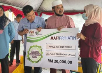 NIK Muhammad Zawawi Nik Salleh (dua dari kanan) menyampaikan replika cek bantuan kepada  peserta agropreeur muda di Pasir Puteh, Kelantan, hari ini.UTUSAN/TOREK SULONG