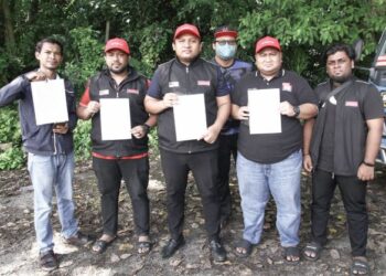 ASHRAF Kahasani  (tengah) menunjukkan laporan polis yang dibuat terhadap Razman Zakaria di IPD Ipoh, Perak, semalam. - UTUSAN/MUHAMAD NAZREEN SYAH MUSTHAFA