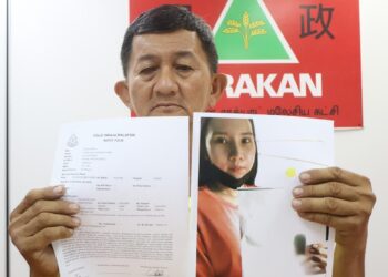 TAN Boon Chai menunjukkan gambar anaknya, Tan Shu Chyi yang gagal dihubungi sejak 1 Mei lalu dalam sidang akhbar di ibu pejabat Gerakan Pulau Pinang di George Town, hari ini. - Pic: IQBAL HAMDAN