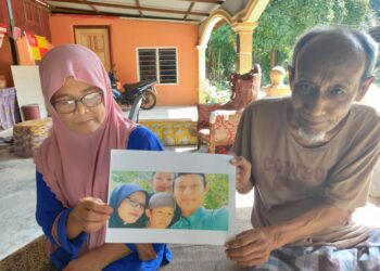 ZALEHA Basar (kiri) dan suaminya menunjukkan gambar kenangan Allahyarham Muhammad Fikri Adam Azmi (kanan sekali) yang mati lemas di Kampar, Perak.