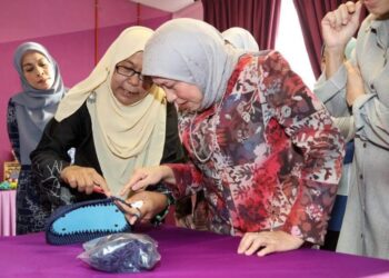 NANCY SHUKRI mendengar penerangan daripada seorang peserta yang mengikuti sesi kemahiran menghasilkan produk sewaktu sesi lawatan kerja ke LaWa cawangan Tasek Gelugor, Pulau Pinang hari ini.