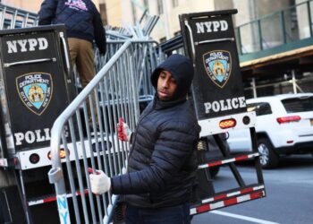 Polis New York menurunkan penghadang logam di hadapan Mahkamah Jenayah Manhattan. -AGENSI