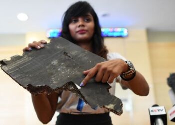 SEORANG daripada anak penumpang pesawat MH370, Grace Subathirai Nathan menunjukkan serpihan yang dipercayai milik pesawat berkenaan di Putrajaya pada November 2018. - AFP