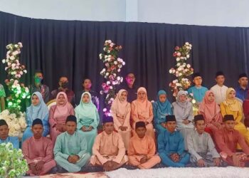 Sebahagian daripada ahli keluarga dan tetamu merakamkan gambar ketika 10 pasangan pengantin bersanding di atas pentas di Pos Betau, Lipis, Pahang baru-baru ini. – UTUSAN/HARIS FADILAH AHMAD