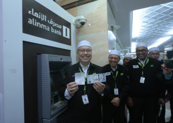 Syed Saleh Syed Abdul Rahman menunjukkan wang yang dikeluarkan daripada ATM Alinma Bank di Abraj Janadriyah, Mekah semalam.