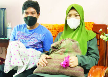 MOHD. Fazlan Nizam Mohamed Hamidi dan Mimi Doleng menunjukkan bantal busuk, kain basahan dan getah rambut yang dijumpai di lokasi kebakaran rumah kedai yang mengorbankan dua anak mereka di Seri Iskandar dekat Parit semalam. – MOHAMAD HAFIZI MOHD. SAID