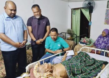 SYAIFUL Rizal Abdul Ghani (berbaju hijau) bersama Pengerusi Belia 4B Padang Besar, Khairul Anwar Ahmad (berdiri, dua dari kiri) menyantuni sendiri keluarga asnaf dari rumah ke rumah untuk menyerahkan bantuan bakul makanan.