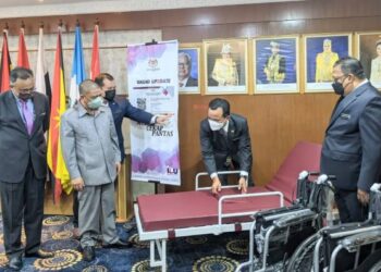SAARANI Mohamad (dua kiri) melihat katil dan kerusi roda yang disumbangkan pada Pelancaran Skuad Up2date dan Penyampaian Sumbangan Murid Berkeperluan Khas di Bangunan Perak Darul Ridzuan di Ipoh hari ini. - UTUSAN/MOHAMAD HAFIZI MOHD. SAID