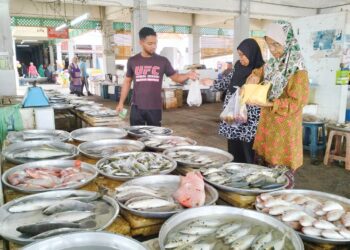 SUZAIRI Rozi menjual ikan kepada pelanggannya di Pasar Besar Wakaf Bharu, Tumpat, Kelantan. – UTUSAN/ROHANA ISMAIL