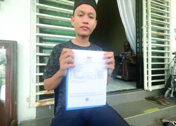 MUHAMMAD Syahril Saidi menunjukkan keputusan  SPM 2022 yang diperolehnya selepas meraih 11A di rumahnya di Kampung Kandis, Bachok, Kelantan. –  UTUSAN/TOREK SULONG