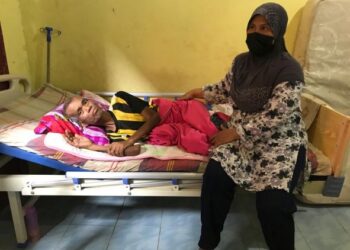 ZAINUN Omar bersama suaminya yang menghidap kanser usus di rumah mereka di Kampung Kijang, Kota Bharu. - FOTO/ROSLIZA MOHAMED