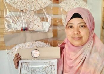SARINAH Said menunjukkan batik kit dan wau batik kit yang dikeluarkan oleh Lambo Sari, Kuala Terengganu. – FOTO/KAMALIZA KAMARUDDIN