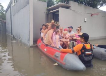 PASUKAN kecemasan memindahkan pelancong asing menggunakan bot selepas sejumlah kawasan di Bali dilanda banjir. - AGENSI