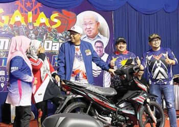 MOHD. Syahbuddin Hashim (tiga dari kanan) menyerahkan hadiah cabutan bertuah, iaitu sebuah motosikal kepada seorang pengunjung di Taman Etnobotani, Gua Musang, Kelantan. - UTUSAN/ AIMUNI TUAN LAH