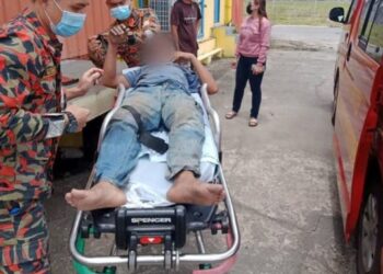 DUA mangsa yang melecur akibat terkena renjatan elektrik semasa memasang papan iklan di Penampang hari ini.-IHSAN BOMBA