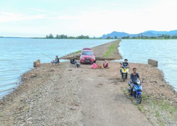 JALAN lama yang pernah lenyap hampir 30 tahun lalu selepas ditenggelami air akibat pembinaan empangan Timah Tasoh muncul kembali setelah air menyusut akibat cuaca panas ketika ini di empangan Timah Tasoh, Padang Besar, Perlis semalam.- UTUSAN/IZLIZAN OTHMAN