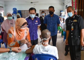 KASEMANI Embong (kiri) menyuntik vaksin Covid-19 kepada seorang penghuni Penjara Marang di Marang hari ini. - PUQTRA HAIRRY ROSLI