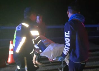 POLIS mengangkat mayat Muhammad Azza Ajmal Aman Ayub yang maut di Kilometer 329.2, LPT berhampiran susur keluar Plaza Tol Kertih di Kemaman, semalam.