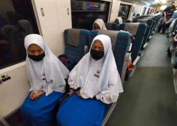 PELAJAR SMK Dabong dari Kampung Kuala Gris memenaiki kereta api di Hentian Kuala Gris, Kuala Krai, Kelantan pagi ini. - UTUSAN/YATIMIN ABDULLAH