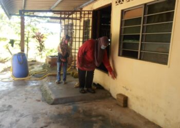 NURHAFIDAH Abu Hassan menunjukkan kesan air di dinding rumahnya selepas kejadian banjir kilat di
Kampung Titi Bakong, Yan, petang kelmarin. - UTUSAN/OTHMAN YAHAYA