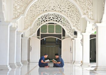 DUA lelaki meluangkan masa dengan membaca ayat-ayat suci al-Quran ketika bulan Ramadan di Masjid Sultan Ismail, Chendering. - UTUSAN/PUQTRA HAIRRY