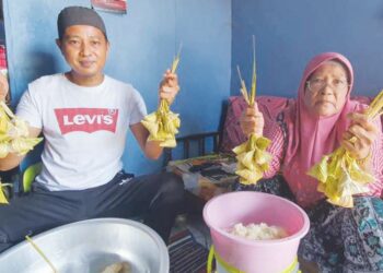 MAT Azri Saleh (kiri) bersama ibunya, Zahrah@Jarah Ishak menunjukkan ketupat yang dihasilkan mereka di Kampung Jabur Kubur, Chukai, Kemaman, Terengganu - UTUSAN/NIK NUR IZZATUL HAZWANI NIK ADNAN