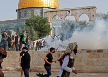 PENDUDUK Palestin melarikan diri daripada gas pemedih mata yang dilepaskan oleh pasukan keselamatan Israel di pekarangan Masjid Al-Aqsa, Baitulmuqaddis. - AFP
