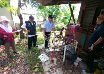 Ngwe Hee Sem meninjau sebuah rumah terbiar yang menjadi tempat pembiakan nyamuk Aedes di Jalan Sekolah Padang Temu, Melaka. UTUSAN/AMRAN MULUP