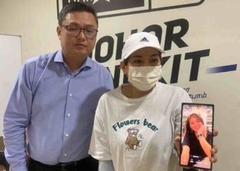 CHOY Won menunjukkan gambar anak perempuannya yang dipercayai hilang di Thailand dalam sidang akhbar di Ibu Pejabat DAP Johor, Kulai hari ini
