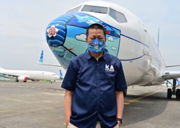 IRFAN Setiaputra berdiri berhampiran pesawat Garuda Indonesia Boeing 373-800 di lapangan terbang Tangerang, Banten. - AFP